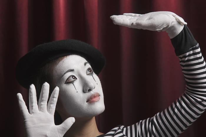 pantomimer Woman in mime costume with arms raised