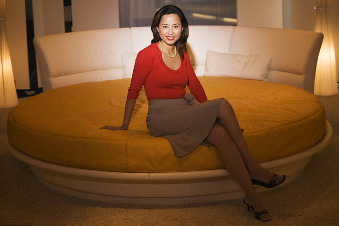 female Asian woman sitting on round bed
