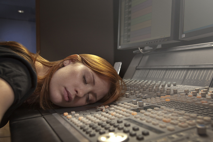 Caucasian woman sleeping on audio control panel