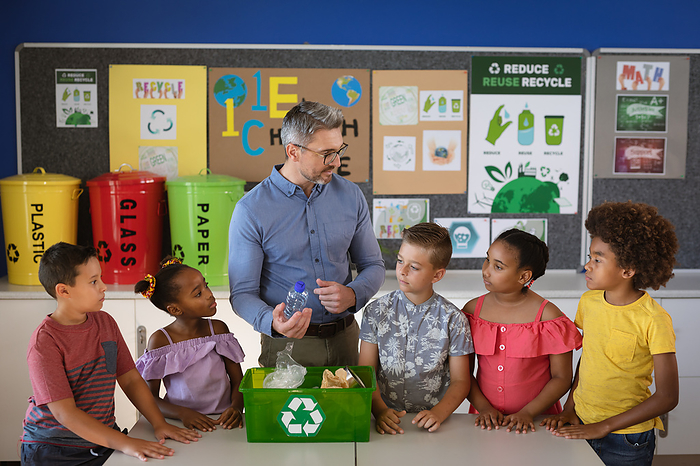 Recycling Class Caucasian male teacher teaching group of diverse students to recycle plastic items at school. school and education concept