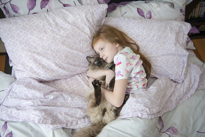 Girl hugging a cat Sick Little Girl Cuddling Cat in Bed