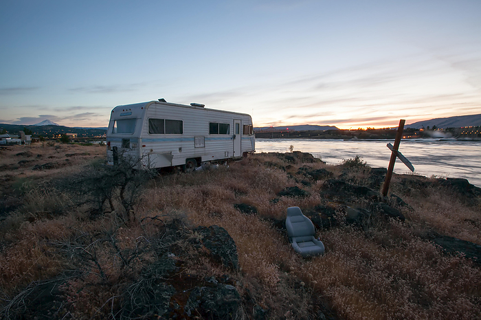 A recreational vehicle parked on the bank of the Columbia River across from The Dalles dam.; Columbia River, The Dalles, Oregon, Photo by Eric Kruszewski / Design Pics