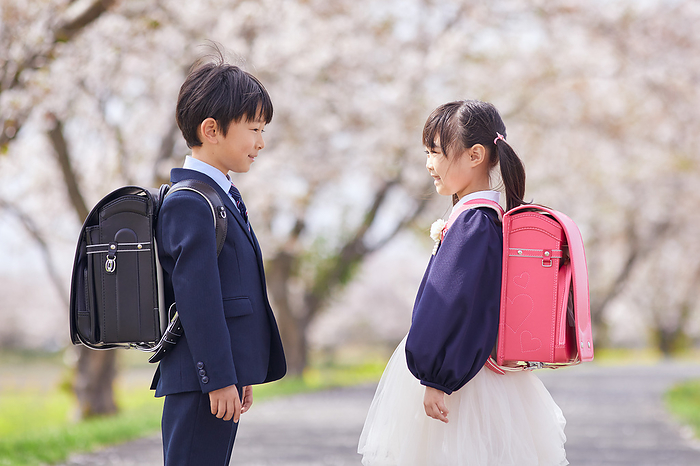 Japanese elementary school students facing the cherry blossoms
