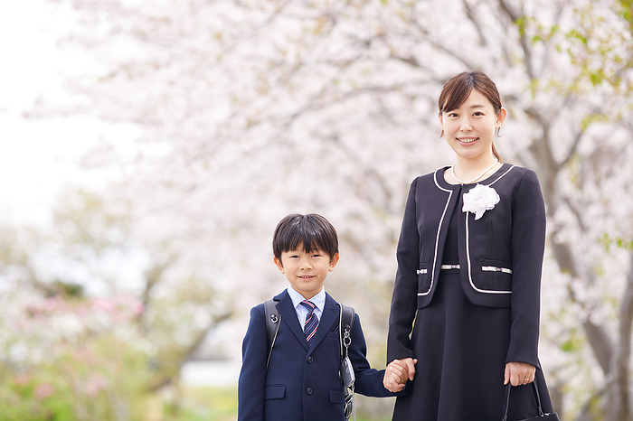 Under the cherry blossoms and a Japanese elementary school boy and his mother
