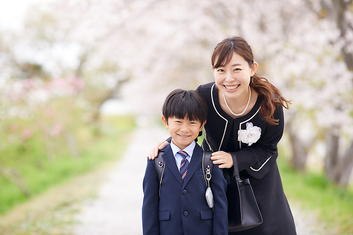 Under the cherry blossoms and a Japanese elementary school boy and his mother