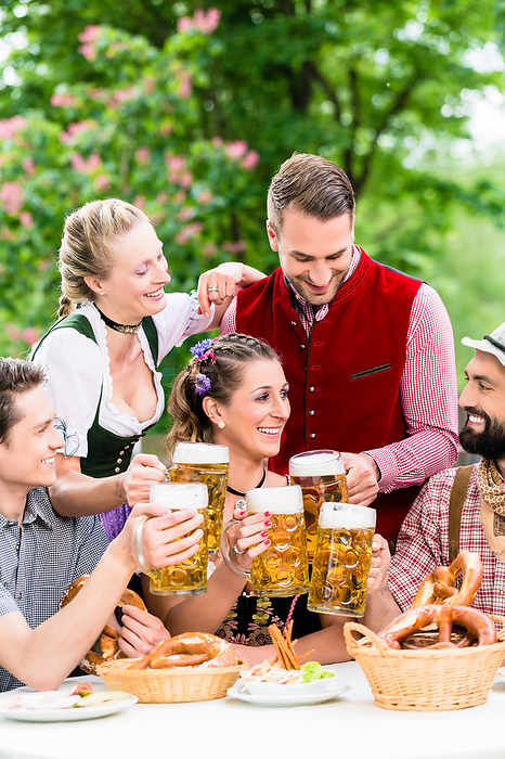 In Beer garden   friends drinking beer in Bavaria In Beer garden   friends in Tracht, Dirndl and Lederhosen drinking a fresh beer in Bavaria, Munich, Germany