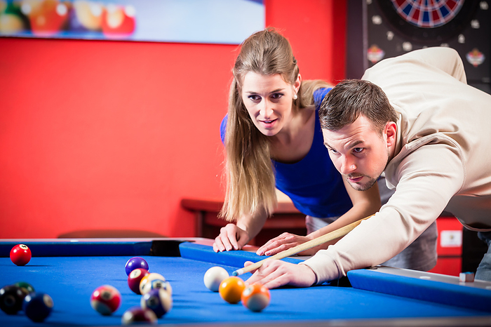 Couple playing pool Portrait of a beautiful young couple playing pool
