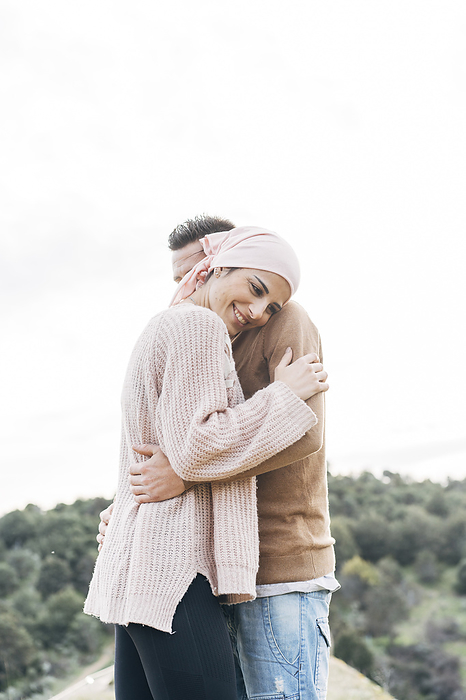 Woman with cancer bandana hugging her boyfriend in Madrid, Spain Smiling girlfriend embracing boyfriend, Photo by David Ag ero Mu oz