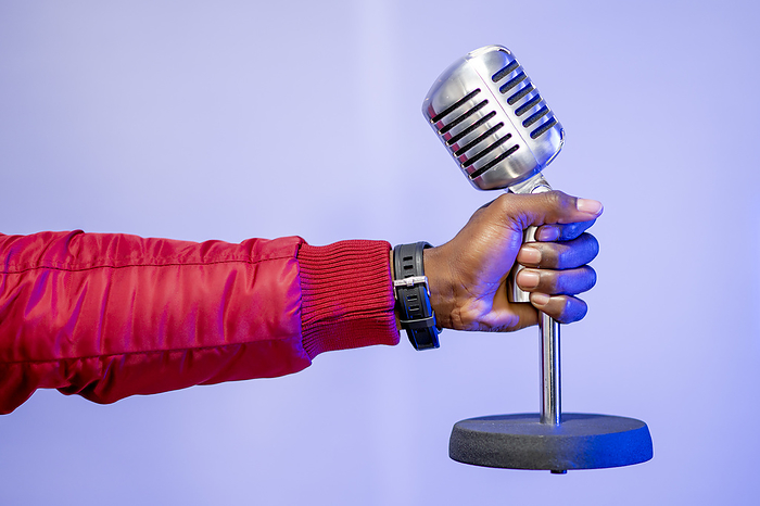 Madrid Spain, funny African man with microphone Male influencer s hand holding microphone over purple wall at studio, Photo by Oscar Carrascosa Martinez
