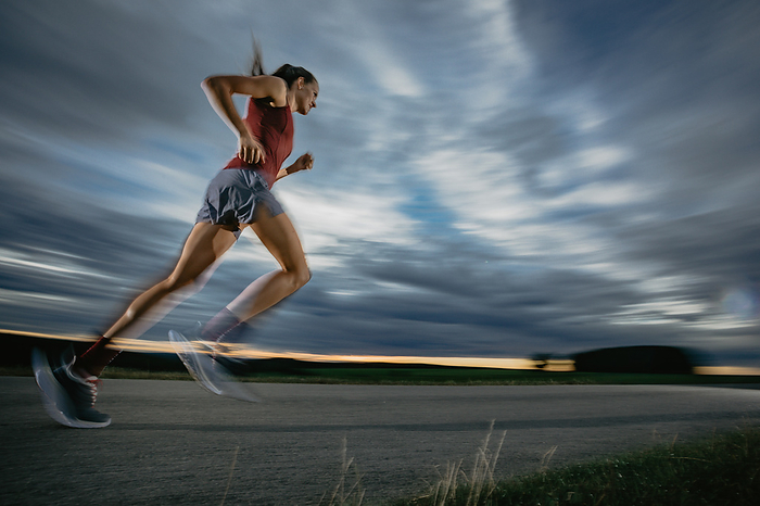 Woman runner runs on road in sunset, sport, forest, Photo by lookphotos / Jorda, Christoph