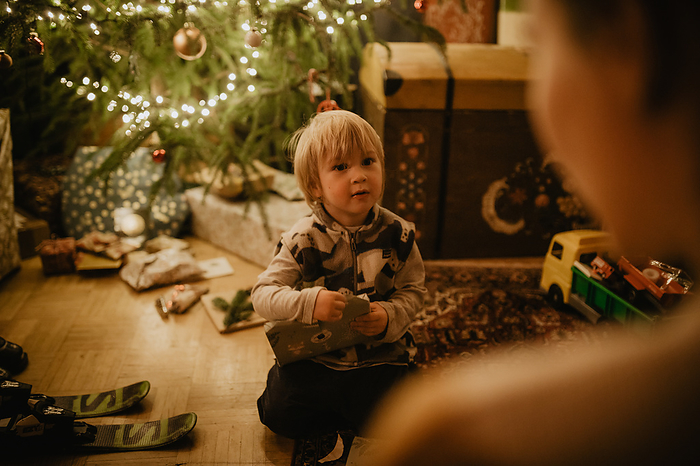 parent and child little boy unwraps his gifts in front of the Christmas tree, Christmas, family, Photo by lookphotos   Jorda, Christoph