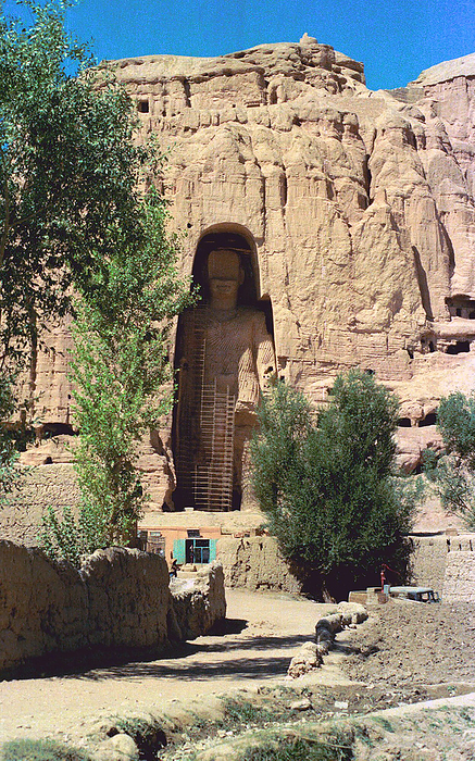 Afghanistan: Bamian Buddha in 1979. The Buddhas of Bamiyan were two 6th century monumental statues of standing buddhas carved into the side of a cliff in the Bamiyan valley in the Hazarajat Bamiyan was two 6th century monumental statues of standing buddhas carved into the side of a cliff in the Bamiyan valley in the Hazarajat region of central Afghanistan, situated 230 km  143 miles  northwest of Kabul at an altitude of 2,500 meters  8,202 ft .  br   br    Built in 507 CE, the larger in 554 CE, the statues represented the classic blended style of Gandhara art. The main bodies were hewn directly from the sandstone cliffs, but details were modeled in mud mixed with straw, coated with stucco. This coating, practically all of which was worn away long ago, was painted to enhance the expressions of the faces, hands and folds of the robes  the larger one was painted carmine red and the smaller one was painted Multiple colors. br   br    The lower parts of the statues  arms were constructed from the same mud straw mix while supported on wooden armatures. The rows of holes that can be seen in photographs were spaces that held wooden pegs which served to stabilize the outer stucco. The rows of holes that can be seen in photographs were spaces that held wooden pegs which served to stabilize the outer stucco. br   br   br  The rows of holes that can be seen in photographs were spaces that held wooden pegs which served to stabilize the outer stucco.  They were intentionally dynamited and destroyed in 2001 by the Taliban, on orders from leader Mullah Mohammed Omar, after the Taliban government They were intentionally dynamited and destroyed in 2001 by the Taliban, on orders from leader Mullah Mohammed Omar, after the Taliban government declared that they were  idols. International opinion strongly condemned the destruction of the Buddhas, which was viewed as an example of the intolerance of the Taliban. Japan and Switzerland, among others, have pledged support for the rebuilding of the statues.
