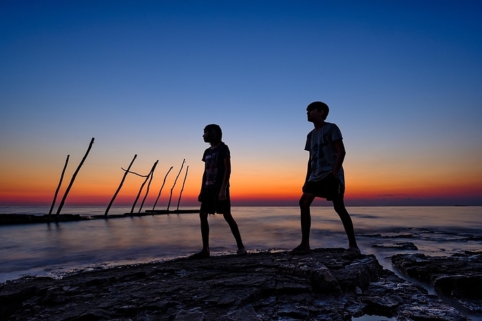 Silhouette of 2 boys by the sea, dusk, Savudrija, Adriatic Sea, Istria, Croatia, Europe, Photo by Herbert Berger