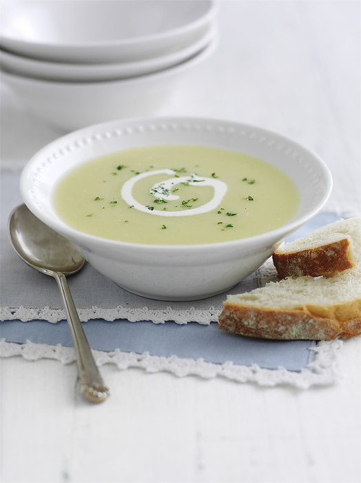 Leek and potato soup Leek and potato soup garnished with swirl of cream and herbs, served with bread., Photo by DK IMAGES SCIENCE PHOTO LIBRARY