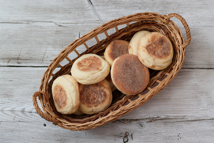English muffins in baskets with wood background