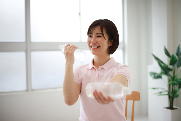 Caregiver performing plastic bottle exercises Image