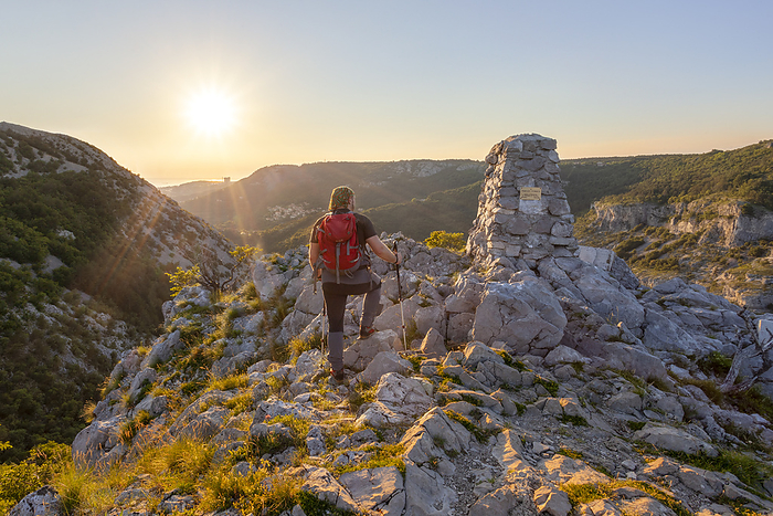 Italy Hiker admires the sunset on Cippo Comici, Rosandra Valley, Trieste province, Friuli Venezia Giulia, Italy., Photo by Diego Cuzzolin