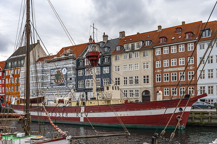 Copenhagen, Denmark Red and white ship at anchor in a Copenhagen canal. In the background, the characteristic brightly colored Danish houses. Copenhagen, Denmark, Europe, Photo by Guido Paradisi