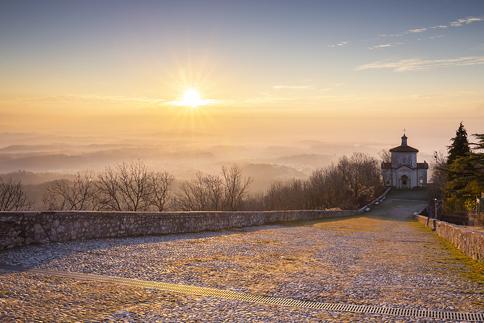 Lombardy, Italy View of the last chapel of the Sacro Monte di Varese with the fog on the Pianura Padana at sunrise. Sacro Monte of Varese. Varese, Lombardy, Italy., Photo by Mirko Costantini