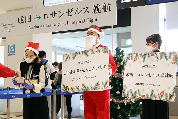Low cost airline ZipAir launched Narita Los Angeles route. December 25, 2021, Narita, Japan   Japan s budget airline Zipair Tokyo president Shingo Nishida  C  in Santa costume and ground staffs greet their customers as the airline launches the first flight from Narita to Los Angeles at the Narita international airport in Narita, suburban  Tokyo on Saturday, December 25, 2021. Japan Airlines   JAL  low cost carrier started its sixth international route to Los Angeles.      Photo by Yoshio Tsunoda AFLO  