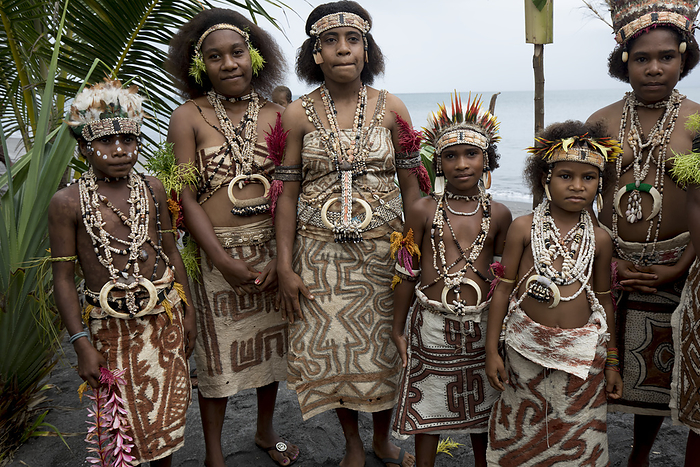 Village girls in tapa bark cloth dresses preparing to perform traditional sing sing Melanesian tribal dance in the Oro Province of Papua New Guinea; Buna Beach, Oro Province, Papua New Guinea, Photo by Chris Caldicott / Design Pics