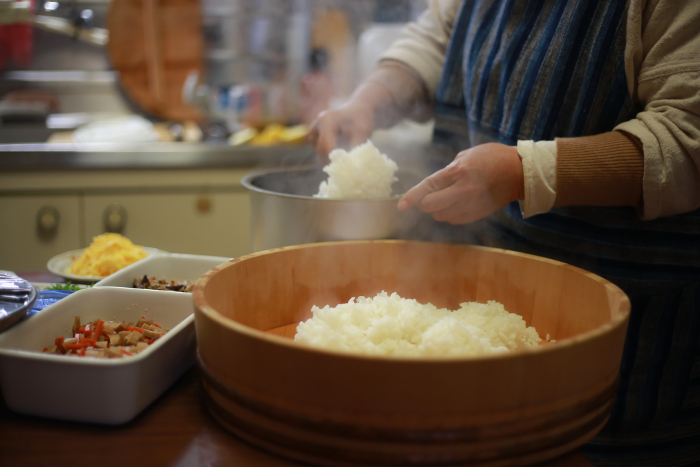 A woman making chirashi-sushi in her hand