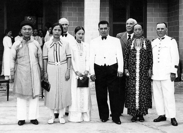 Deo Van Long  left , Lord of the Tai Federation of Sipsongchuthai  Lai Chau 1887   Toulouse 1975  at the wedding of his daughter   Under his father Deo Van Tri, he was the scion of a hereditary feudal noble line with roots in Yunnan province.  br   br  Under his father Deo Van Tri, he was the scion of a hereditary feudal noble line with roots in Yunnan province.  He compelled the Hmong of the Federation to sell to him at below market prices, thus making enormous profit from his sales to the French, This made him rich, but severed his relationship with the Hmong of the Federation, who supported the Viet Minh during the First Indochina War. His use of force to suppress Hmong resistance also decreased his popularity with the Hmong. br   br   br  Hmong resistance also decreased his popularity with the Hmong.  As the Dien Bien Phu campaign came to an end, he was helicoptered away to Hanoi. He later immigrated to France as a refugee, but died shortly thereafter. was succeeded by Deo Nang Toi.