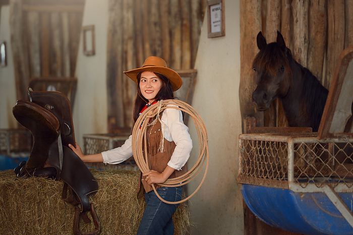 female Cowgirl working stables.Concept of retro woman in horse ranch