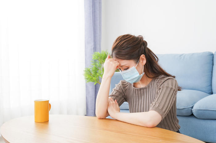 Woman wearing a mask suffering from ill health