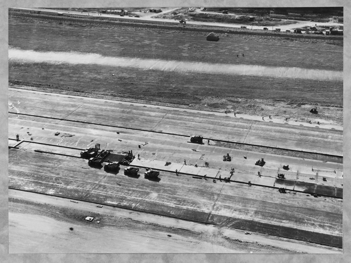 Filton Airfield, South Gloucestershire, 01 09 1947. Creator: John Laing plc. Filton Airfield, South Gloucestershire, 01 09 1947. An aerial view showing trucks and workmen on the runway at Filton Airfield during concreting. Laing extended the runway westwards at Filton Airfield to accommodate the Bristol Brabazon airliner, which was being built at the airfield. Work began in July 1946 on the new runway, which was 2,725 yards long and 100 yards wide. The work required the requisitioning and removal of Charlton village and a temporary flying strip was laid, for use while the new runway was under construction. The negative of this print was digitised and catalogued as part of the Britain from Above project.