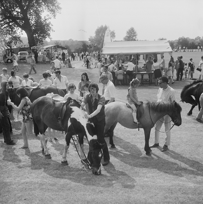 Laing Sports Ground, Rowley Lane, Elstree, Barnet, London, 14 06 1969. Creator: John Laing plc. Laing Sports Ground, Rowley Lane, Elstree, Barnet, London, 14 06 1969. A Gala Day at the Laing Sports Ground at Elstree, showing children s pony rides in the foreground with stalls and crowds beyond. A Gala Day was held by Laing at the Laing Sports Ground on 14th June 1969, as a replacement of the annual Sports Day. Sports events were held by the Sports Club, which included hockey, tennis, bowls, and football tournaments. A traditional English fete programme featured coconut shies, bingo, pony rides, catering and a beer tent, candy floss, and roundabouts. The day ended with a beauty contest, prize draw, and the election of Miss Sports Club. In the evening there was a fireworks display and a gala dance which continued until midnight.