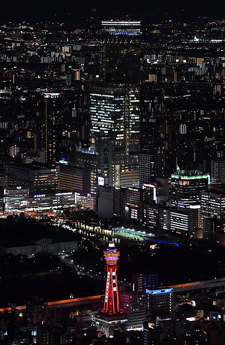 Abeno Harukas, behind Tsutenkaku Tower, is lit up in red to coincide with the turning on of the  red light  of the Osaka Model, Osaka Prefecture s own standard for the spread of new coronaviruses. Abeno Harukas behind Tsutenkaku Tower lit up in red to coincide with the turning on of the  red light  of the Osaka Model, Osaka Prefecture s own standard for the spread of the new coronavirus  Naniwa Ward, Osaka City, 2022 . Photo by Kenji Kiba from the head office helicopter at 6 p.m. on January 24.