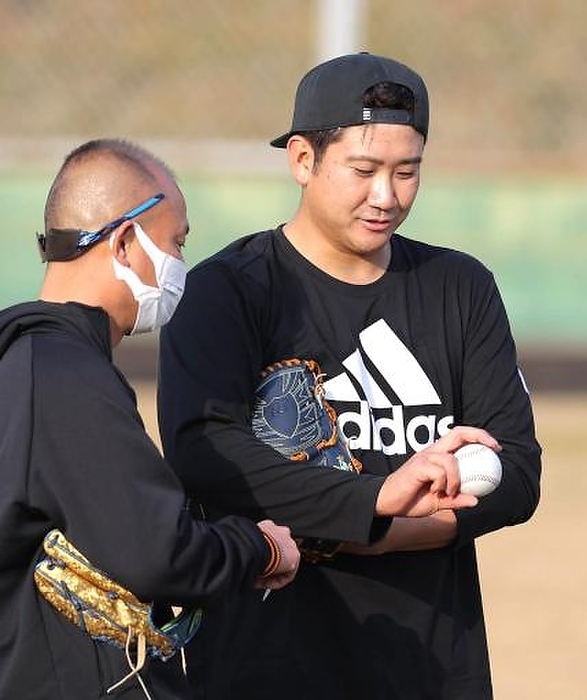 Giants Joint Practice Tomoyuki Sugano of the Giants talks with Hideki Asai, left, about how to grip a ball. This photo was taken on January 28, 2022, at Miyazaki Prefectural Sports Park. Published on January 29. 