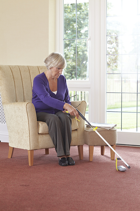 Older woman sitting in a chair using a pick up stick Older woman sitting in a chair using a pick up stick., Photo by DK IMAGES SCIENCE PHOTO LIBRARY