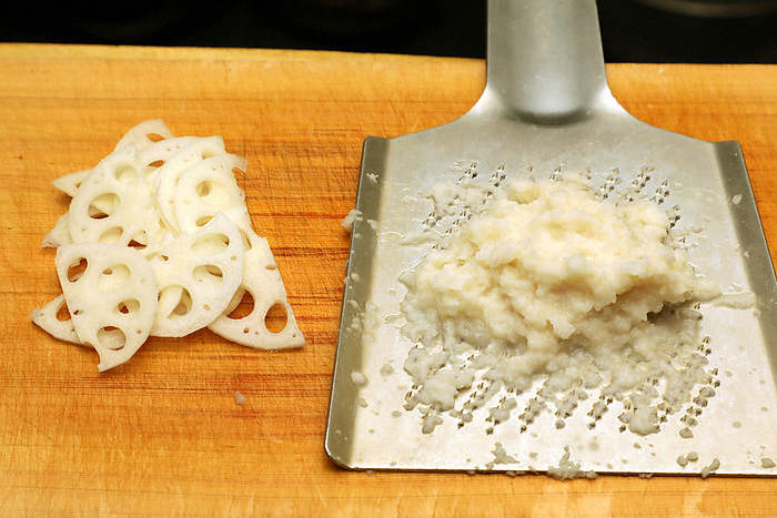 Peel and thinly slice one third of the lotus root. Grate the rest. Peel and thinly slice one third of the lotus root. The rest is grated. Photo by Akihiro Ogome on October 27, 2021 in Shibuya Ward, Tokyo.