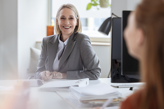 Smiling senior businesswoman at office desk, Photo by Florian Küttler