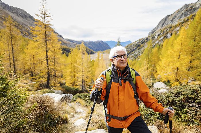 Senior tourist wearing eyeglasses contemplating on mountain at Rhaetian Alps, Italy, Photo by Michela Ravasio