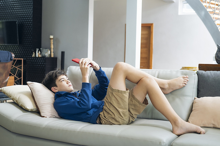 The boy playing online game on smartphone at home, Chiang Mai, Chiang Mai, Thailand