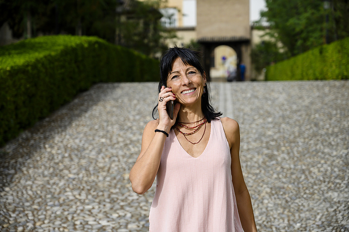 Smiling woman talking through mobile phone on sunny day