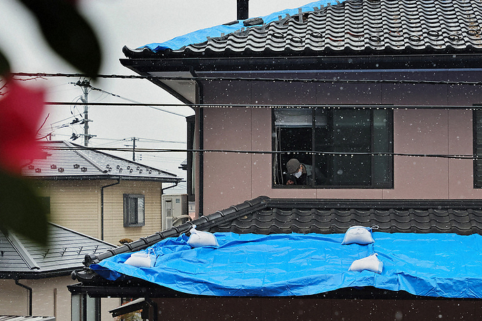 Earthquake of magnitude 6  in southern Tohoku A man, 75, checks the blue sheets on the roof where tiles fell during the earthquake. Sleet is falling,  he said. We managed to put it over the roof yesterday while the weather was good, but I m not sure if it will hold out when the rain gets heavier. Photographed at 10:30 a.m. on August 8 by Daisuke Wada.