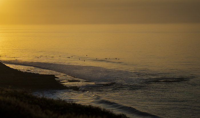 Bells Beach at dawn BELLS BEACH, AUS 16 APRIL 2022: Surfers enjoying perfect dawn conditions at Winkipop, Bells Beach in Victoria, Australia during the WSL Rip Curl Pro Bells Beach 2022. The competition has been held annually at Easter time at Bells Beach continuously since 1961.