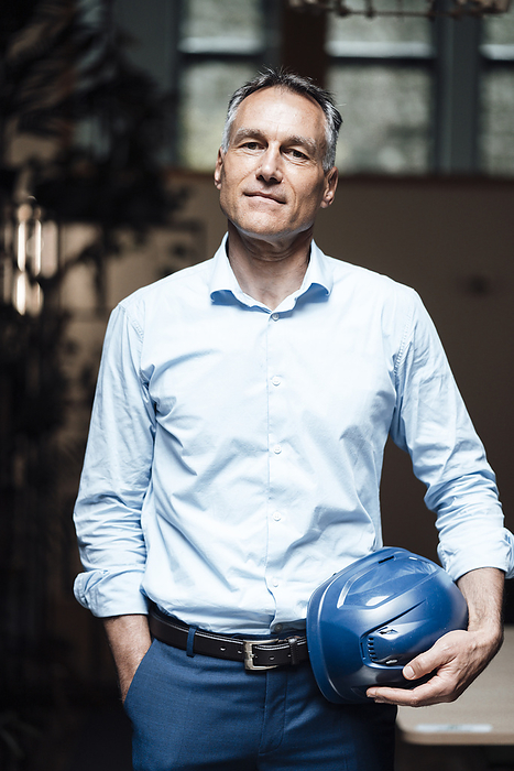 Confident architect with hardhat standing in office, Photo by Joseffson