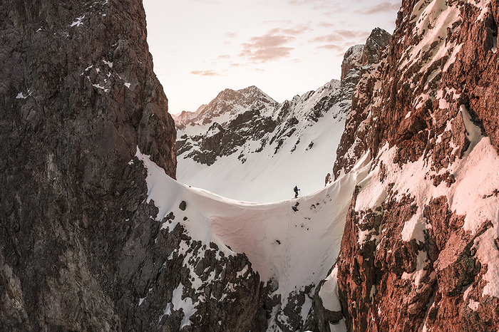 Tourist walking on snow covered mountain at sunrise, Ehrwald, Tirol, Austria, Photo by Wilfried Feder
