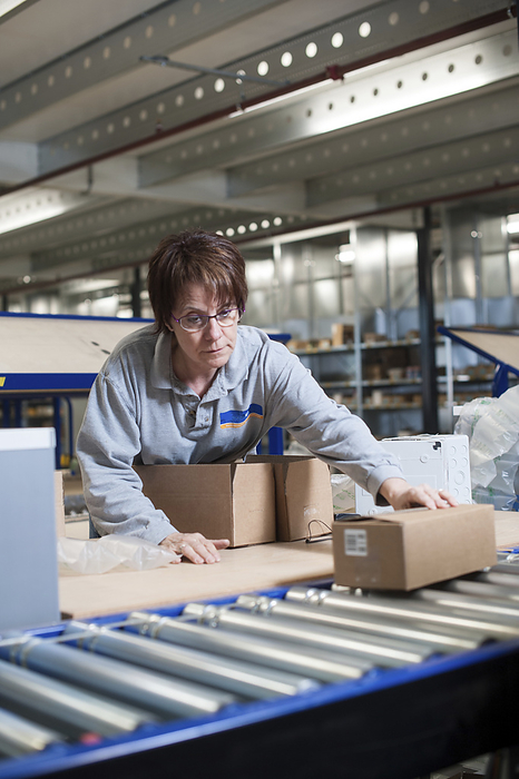 Worker packaging a customer s order in a warehouse Worker packaging a customer s order in a warehouse., by ARNO MASSEE SCIENCE PHOTO LIBRARY