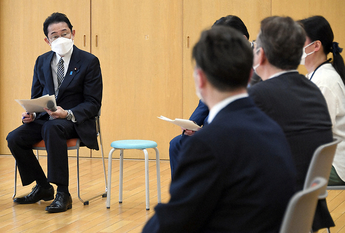 Prime Minister Fumio Kishida exchanging views in a round table discussion with a commissioner for civilian residents and children. Prime Minister Fumio Kishida  left  exchanges views in a round table discussion with a commissioned welfare and childcare worker at the ward Shinkawa Children s Hall in Chuo ku, Tokyo, May 1, 2022. 8:45 a.m., May 2, 2022  Photo by Representative Director 