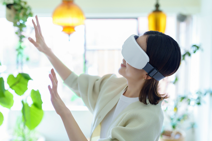 Japanese woman wearing VR goggles and groping in a room (People)