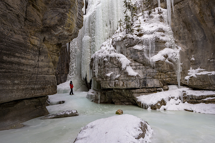 A male wearing red coat stood in Maligne Canyon during winter conditions, Alberta, Canada A male wearing red coat stood in Maligne Canyon during winter conditions, Jasper National Park, UNESCO World Heritage Site, Alberta, Canada, North America, Photo by Ed Rhodes