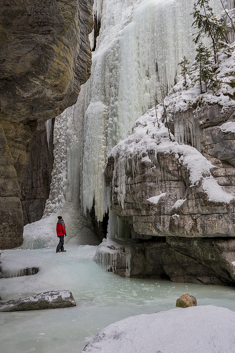 A man wearing red coat stood in Maligne Canyon during winter conditions, Alberta, Canada A man wearing red coat stood in Maligne Canyon during winter conditions, Jasper National Park, UNESCO World Heritage Site, Alberta, Canada, North America, Photo by Ed Rhodes