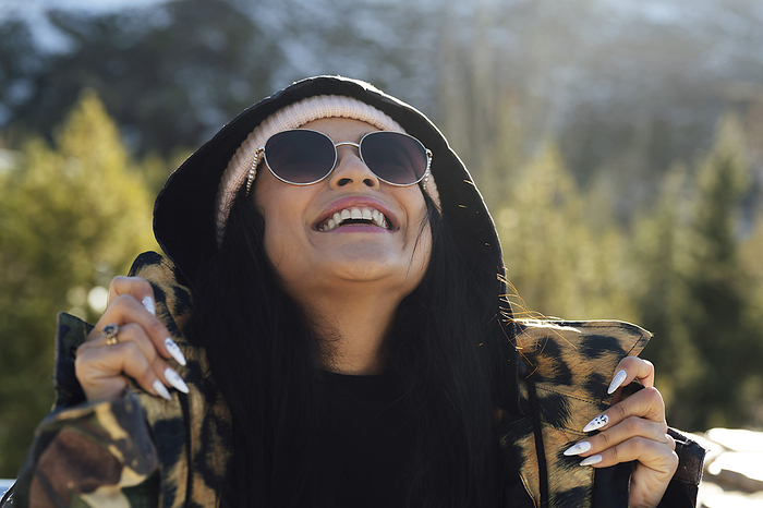 Happy woman wearing sunglasses looking up on sunny day