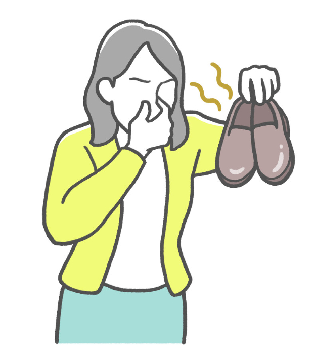 Japanese woman sniffing shoes with her nose pinched